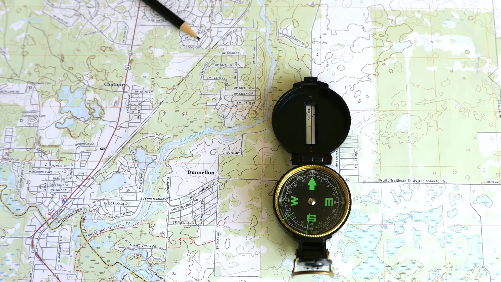 Topographic map with a compass and pencil laid on top