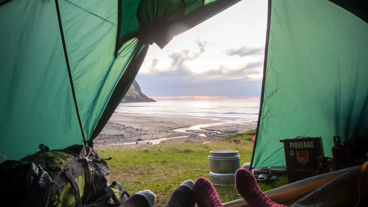 View from inside a two-person tent looking out at a coastal sunrise