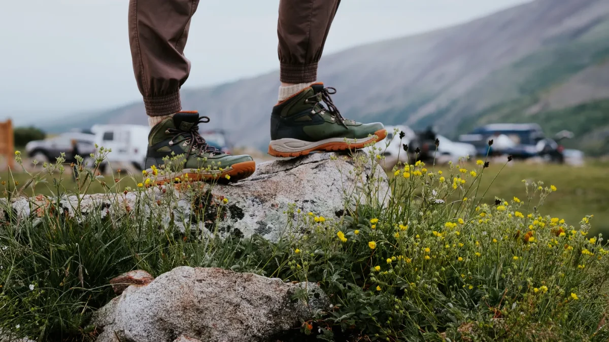 Hiker's boots on a rocky outcrop above a wildflower valley in Alma, Colorado
