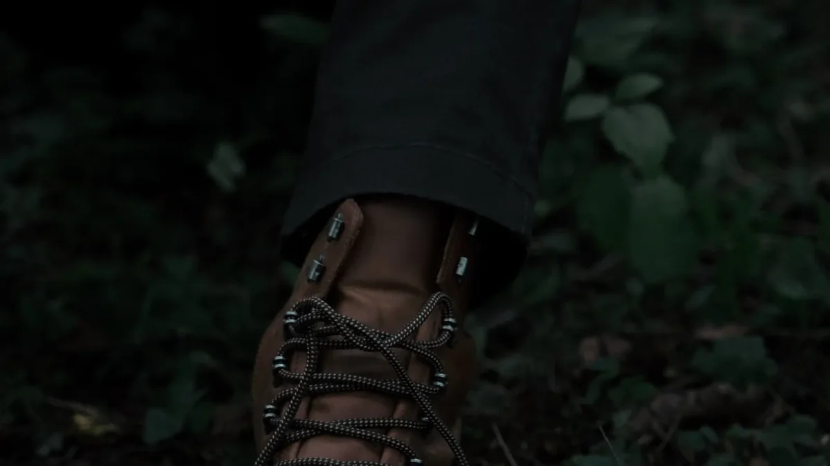 Close-up of a leather hiking boot's laces in a quiet forest