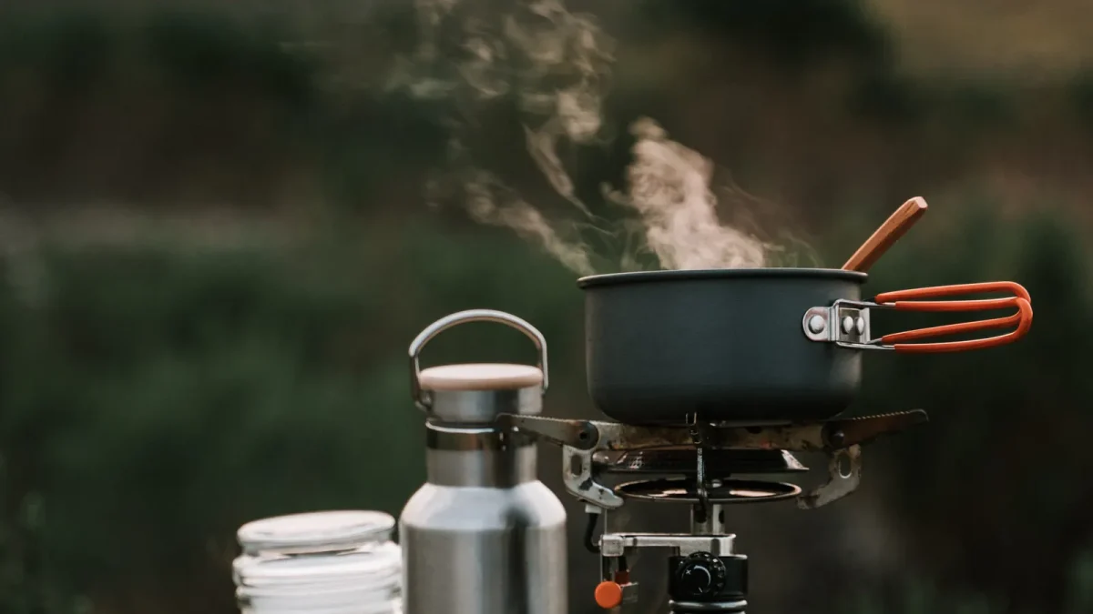 Steam rising from a pot with an orange handle on a canister stove