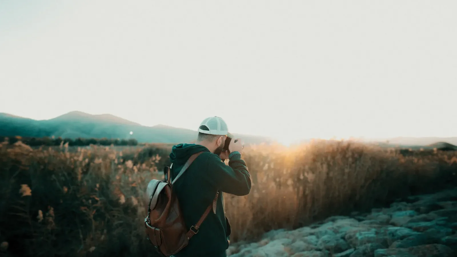 Hiker with a camera photographing a mountain sunset in Shiraz, Iran