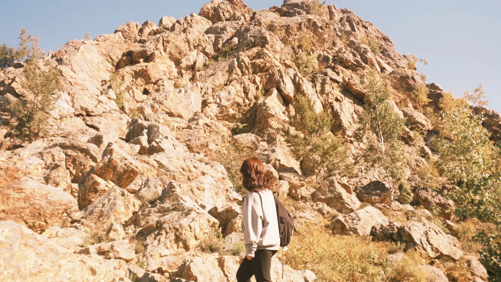 Woman hiking a rocky mountain trail wearing hiking pants