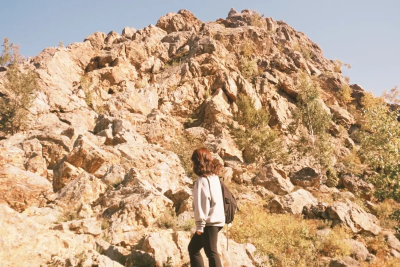 Woman hiking a rocky mountain trail wearing hiking pants