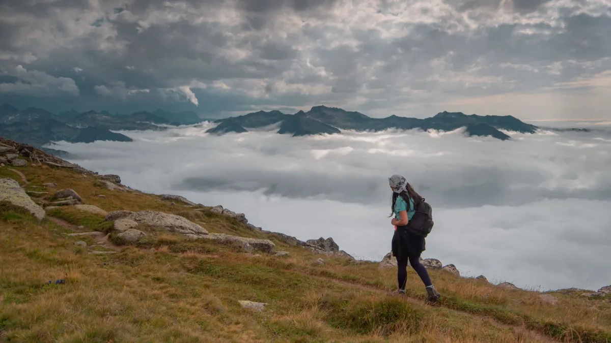 Hiker walking a misty mountain ridge above the clouds in Turkey