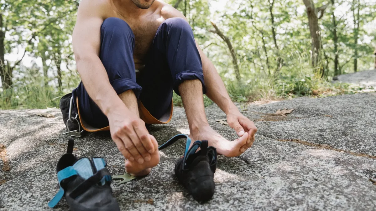 Hiker sitting on a rock checking his bare feet