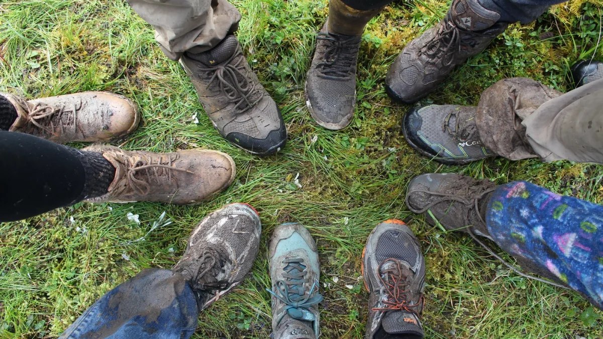 Circle of hikers' mud-caked boots on a trail