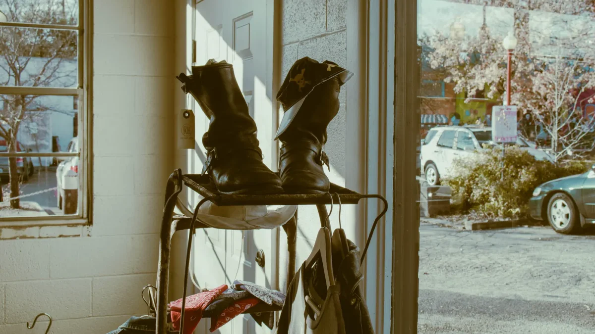 Leather boots stored on a rack near a sunlit doorway