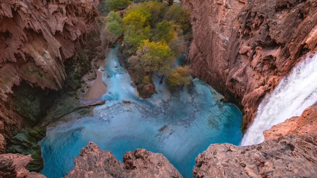 Aerial view of turquoise pools cutting through a red rock canyon